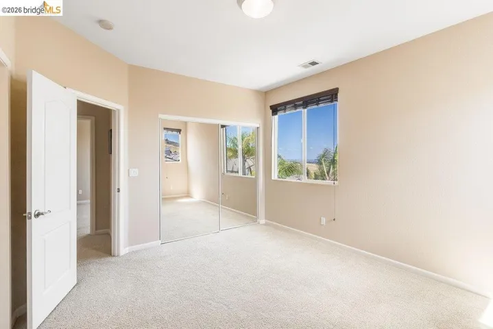 Unfurnished bedroom featuring light colored carpet and a closet
