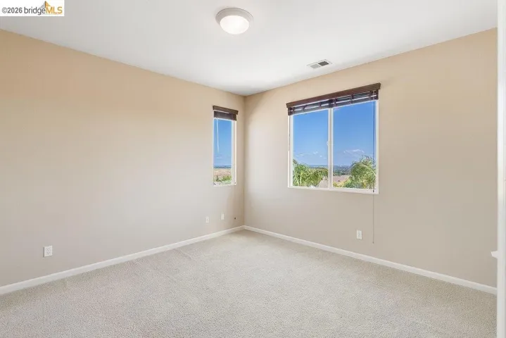 Spare room with light carpet and baseboards