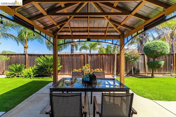 Fenced backyard with a patio, outdoor dining space, and a gazebo