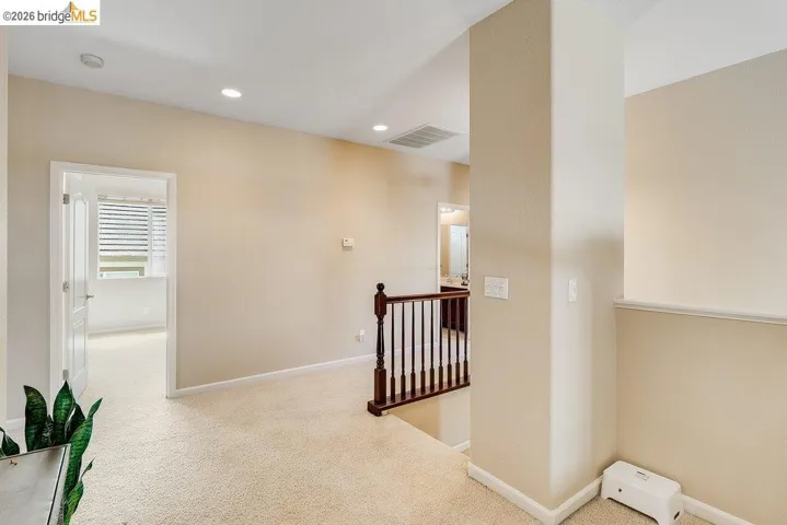 Hallway with light carpet, an upstairs landing, and recessed lighting