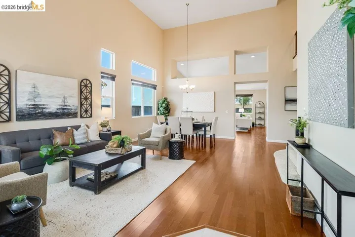 Living room with hardwood / wood-style floors, a high ceiling, and a chandelier