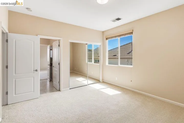 Unfurnished bedroom with light carpet and a closet