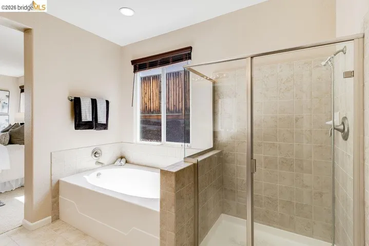 Bathroom with ensuite bath, a shower stall, and a garden tub