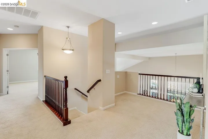Hall featuring light colored carpet, recessed lighting, an upstairs landing, and vaulted ceiling
