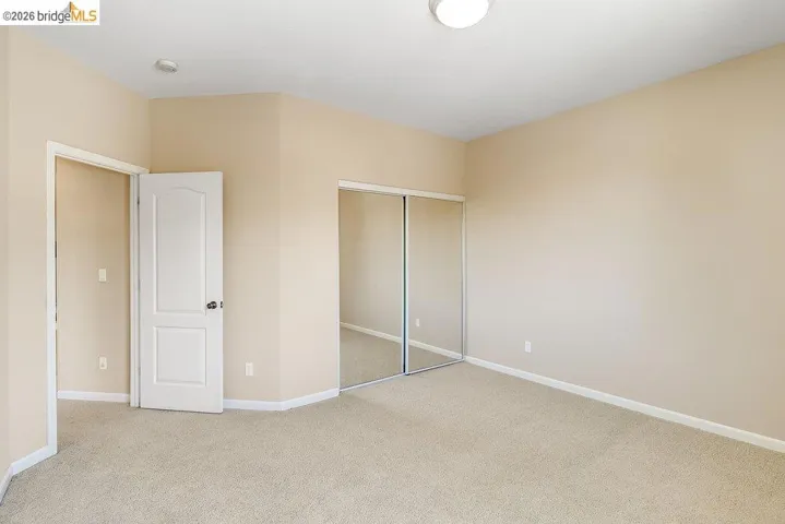 Unfurnished bedroom featuring a closet and light carpet