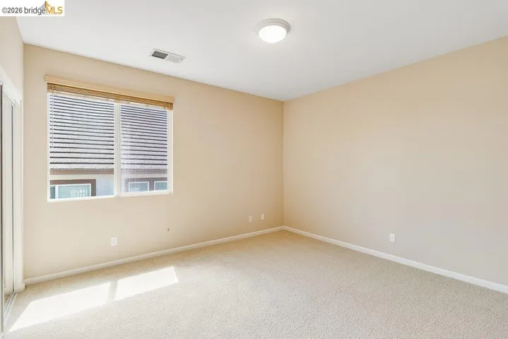 Unfurnished room featuring baseboards and light carpet