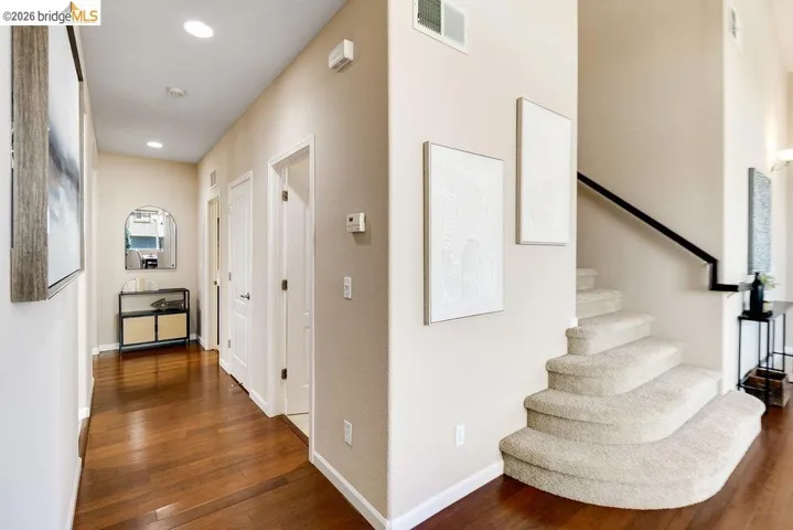 Hallway with dark wood-style floors and recessed lighting