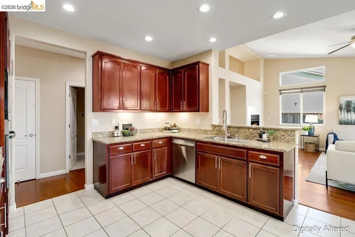 Kitchen with light tile patterned floors, open floor plan, light stone countertops, vaulted ceiling, and recessed lighting