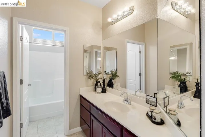 Bathroom featuring vanity, a bathtub, and light tile patterned floors