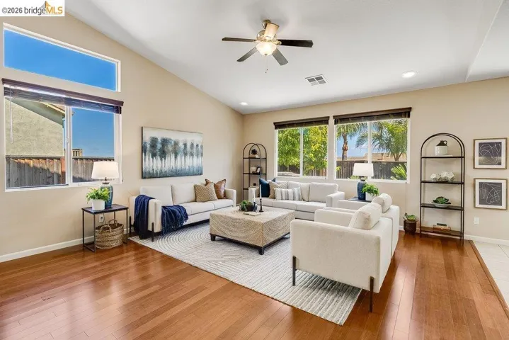 Living room with a ceiling fan, hardwood / wood-style flooring, recessed lighting, and lofted ceiling