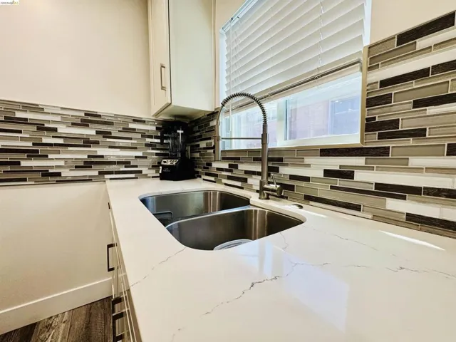 Kitchen view of white cabinetry and light stone countertops
