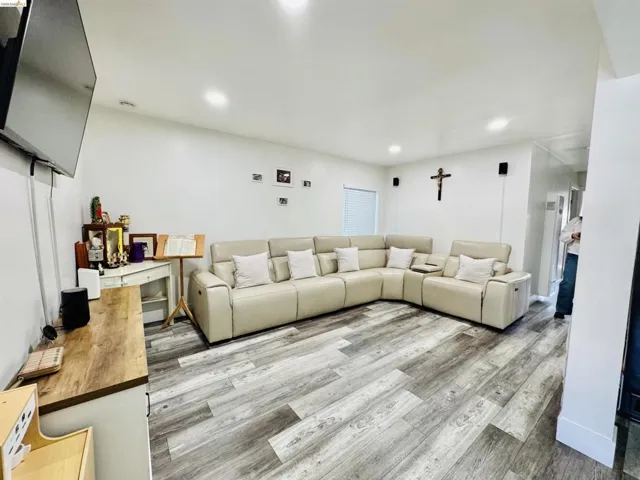 Living area with light wood-type flooring and recessed lighting