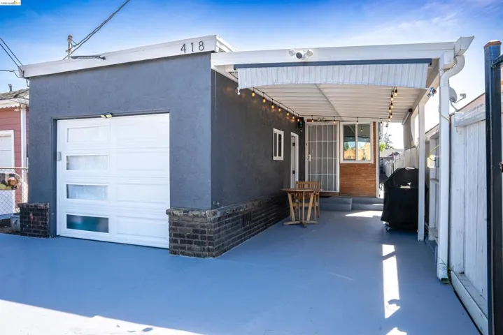Exterior space with stucco siding, a patio, and a garage