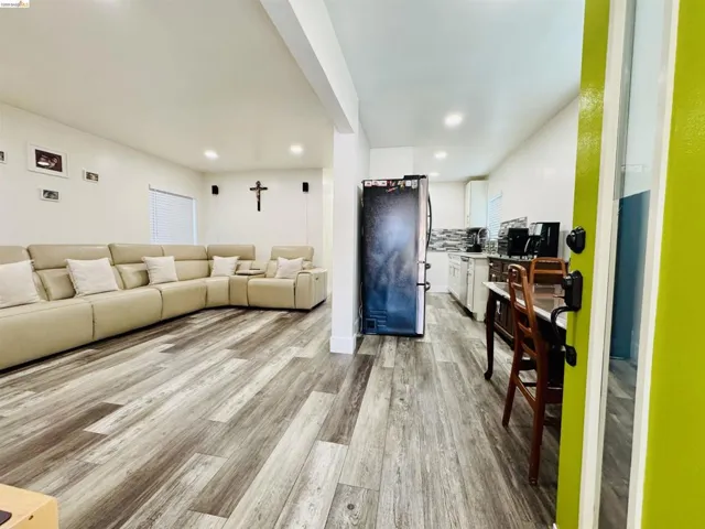 Living room with light wood-style flooring and recessed lighting