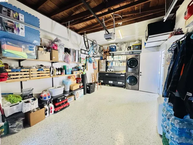 Storage area with a garage and stacked washing machine and dryer