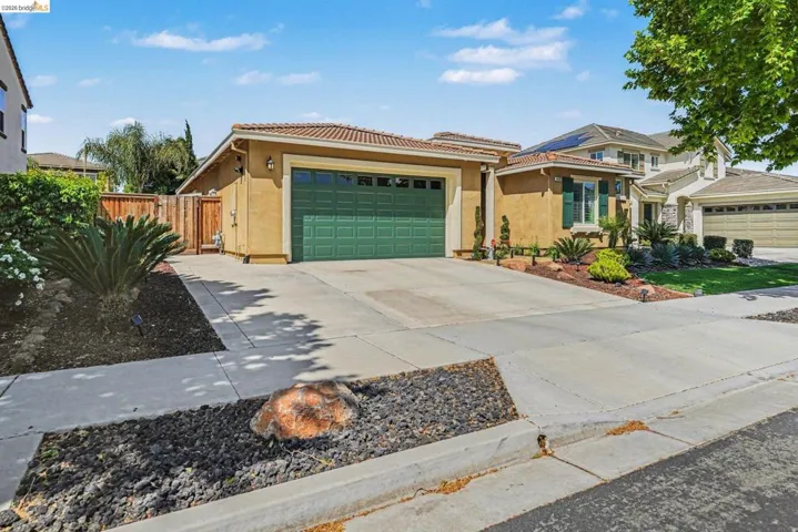 View of front of house with stucco siding, concrete driveway, a garage, and a tile roof