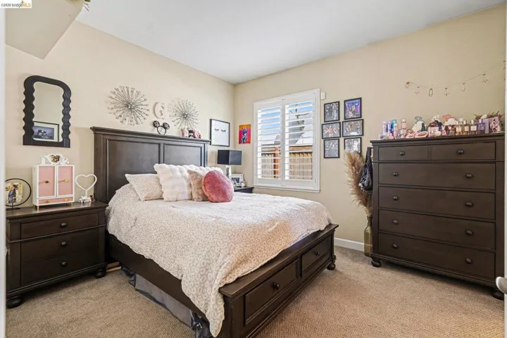 Bedroom with light colored carpet and baseboards