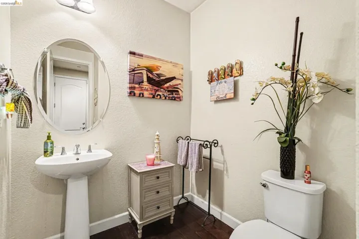 Bathroom featuring a textured wall and dark wood finished floors
