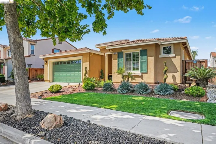 Mediterranean / spanish home with stucco siding, driveway, a garage, and a tiled roof