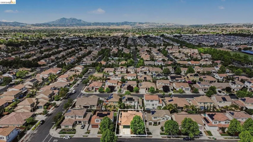 Aerial perspective of suburban area featuring property parcel outlined and a mountainous background
