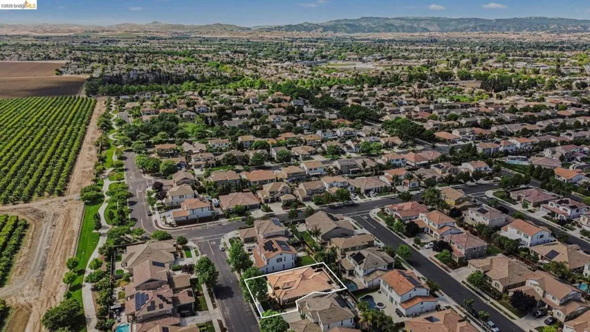 Aerial view of property and surrounding area featuring property parcel outlined and mountains
