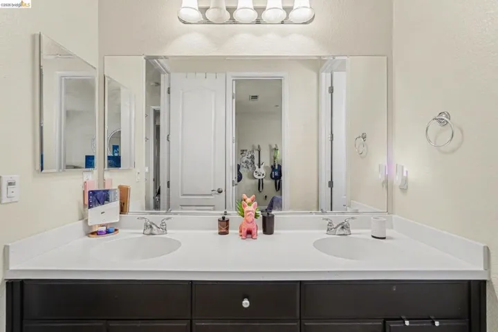 Full bathroom with a textured wall and double vanity