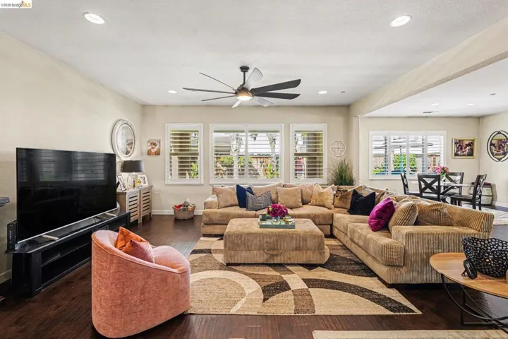 Living room featuring hardwood / wood-style flooring, ceiling fan, and recessed lighting