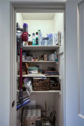 Closet wired with lighting that turns on automatically as the respective door is opened. This hall closet is also equipped with a hand-operated Dyson vacuum