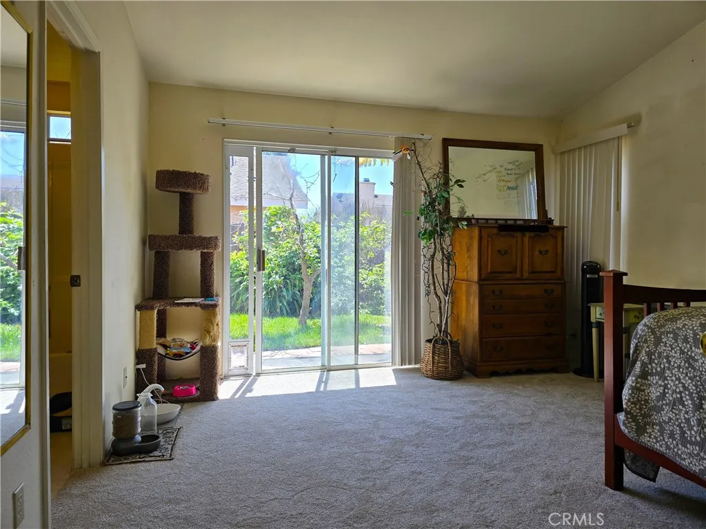 A bright primary suite with warm southern light and a slider leading straight to the backyard, creating a seamless flow from restful retreat to outdoor relaxation.