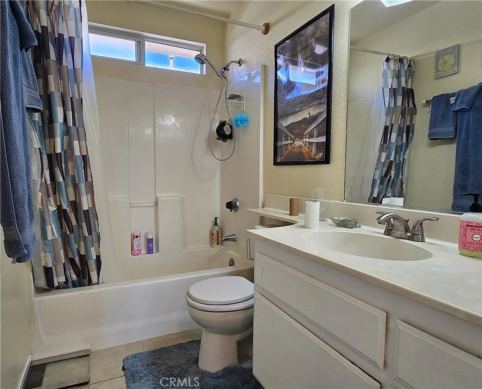 Bright, functional main bath with a solid-surface counter, easy-care tile floors, and a full tub/shower for versatile comfort.