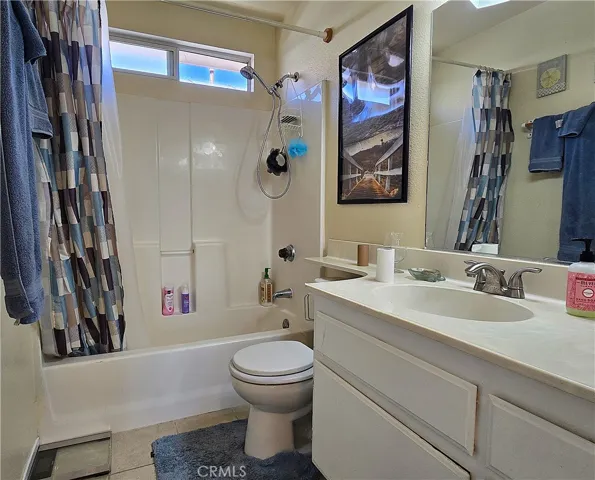 Bright, functional main bath with a solid-surface counter, easy-care tile floors, and a full tub/shower for versatile comfort.