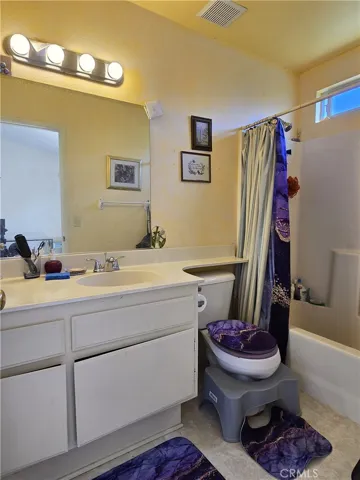 Primary bathroom offers a solid surface counter, tile flooring, and a full tub/shower, with steady natural light from the south facing window.