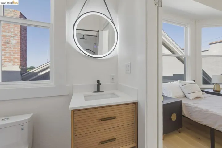 Ensuite bathroom featuring vanity and light wood-style floors