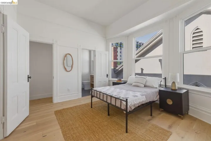 Bedroom featuring light wood-style flooring and connected bathroom