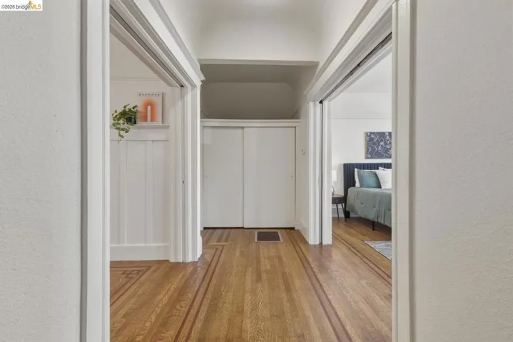Hallway with a textured wall and light wood-type flooring