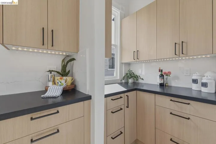 Kitchen with light wood finish cabinets, modern cabinets, and decorative backsplash