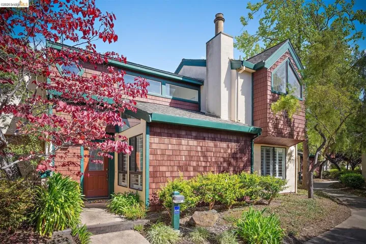 View of front of property with a chimney and a shingled roof