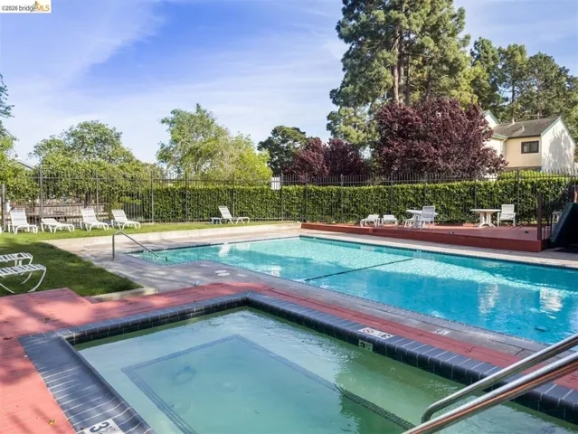 Community pool featuring a community hot tub and a patio area