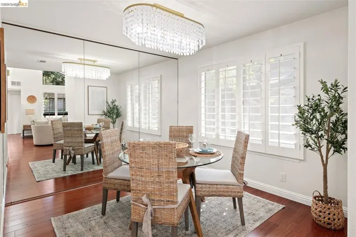 Dining area featuring dark wood-style flooring and suspended lighting