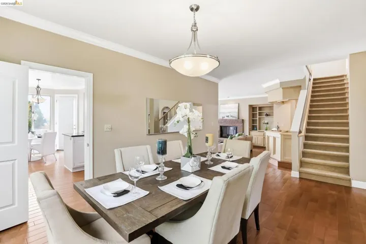 Dining space with ornamental molding and wood-type flooring