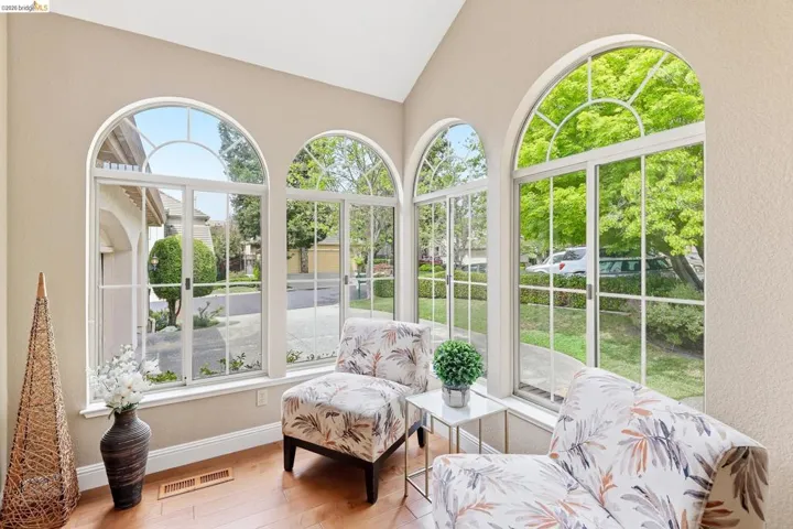 Sunroom / solarium featuring a textured wall, lofted ceiling, and wood-type flooring