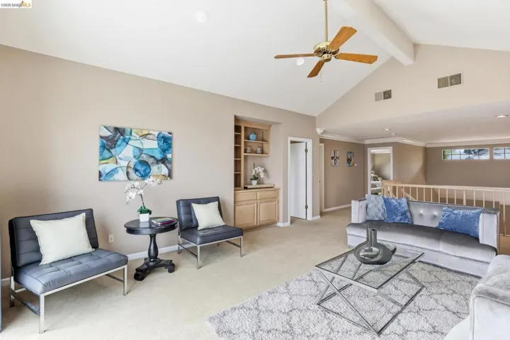 Living area with a ceiling fan and light carpet