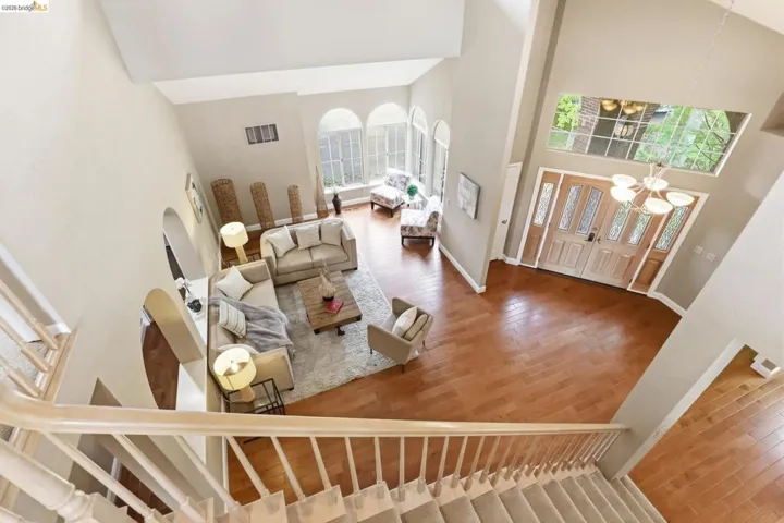 Foyer entrance with hardwood / wood-style flooring, vaulted ceiling, a chandelier, and healthy amount of natural light
