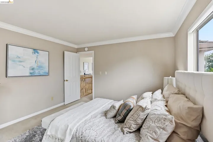 Carpeted bedroom featuring crown molding