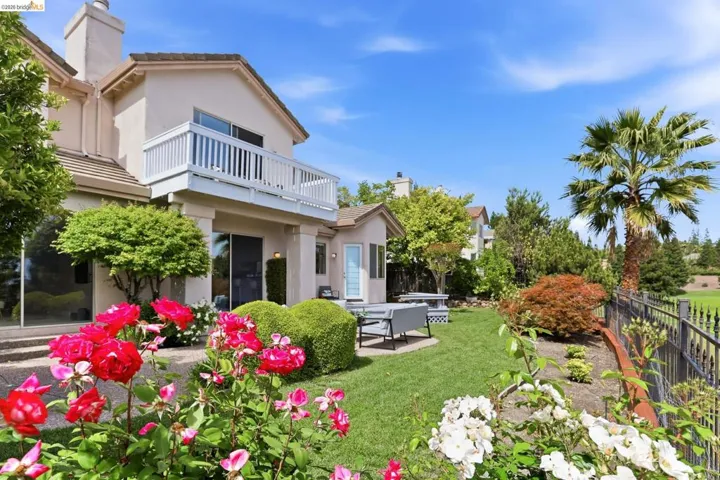 Fenced backyard featuring a patio and a balcony