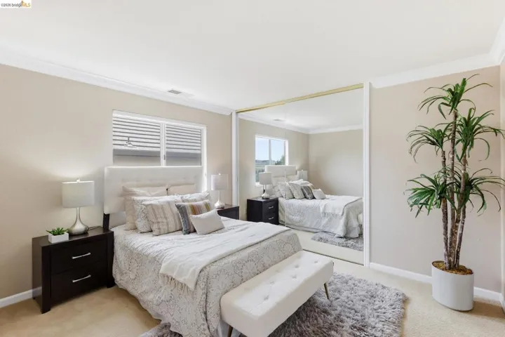 Bedroom featuring crown molding and light carpet