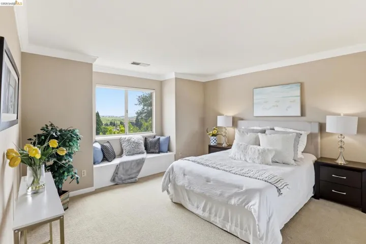 Bedroom with light colored carpet and ornamental molding