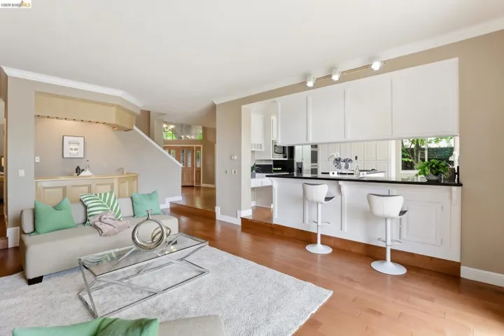 Living area with ornamental molding and light wood-style floors