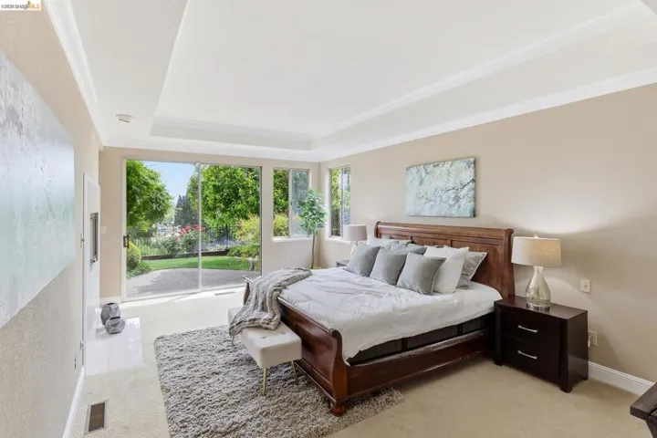 Bedroom featuring light carpet, crown molding, and access to exterior