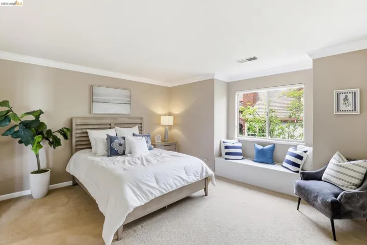 Carpeted bedroom with ornamental molding